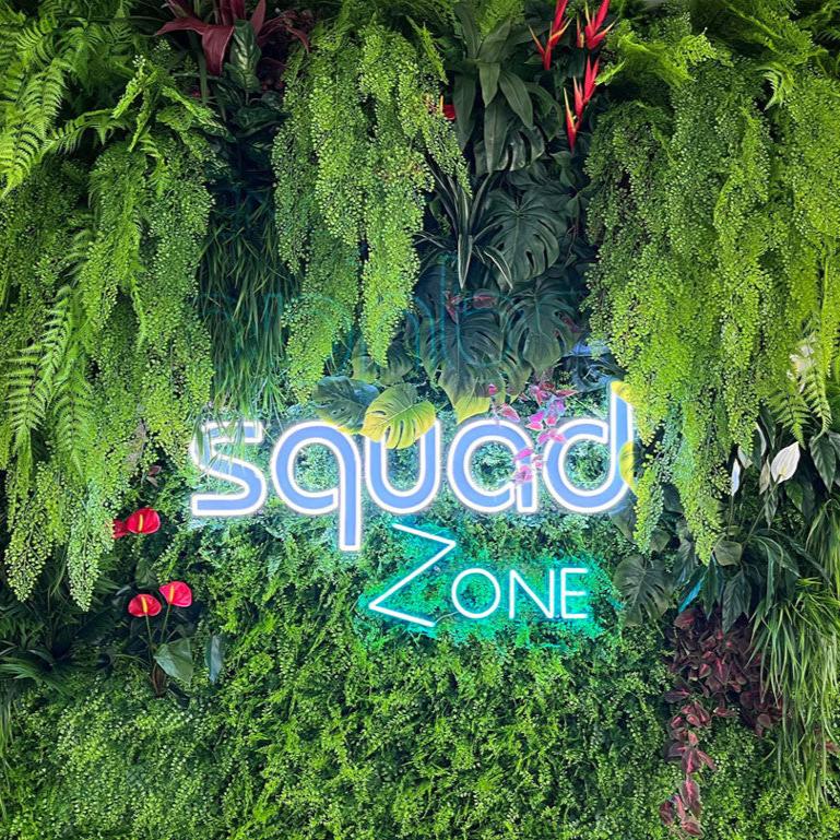 SquadZone custom neon sign on green wall